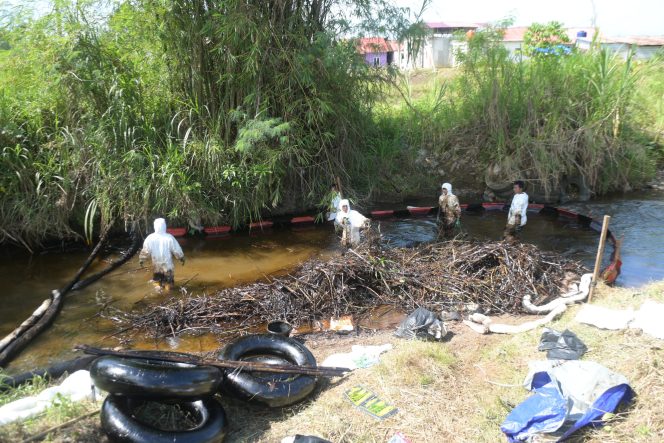 
 Petugas membersihkan sisa tumpahan minyak di sungai Towuti.